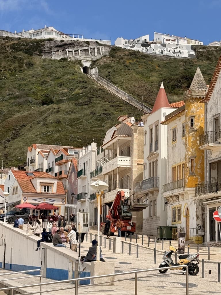 Sunny coastal town with traditional buildings and a hillside funicular